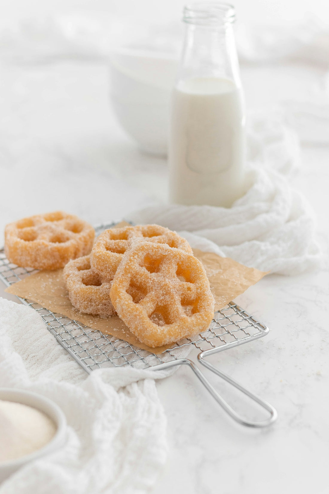 a couple of muffins on a napkin next to a bottle of milk