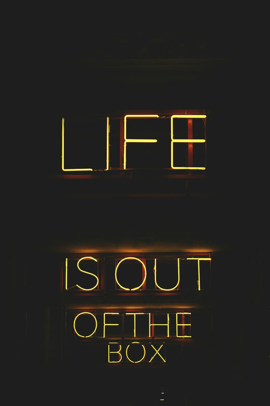 a neon sign that says life is out of the box