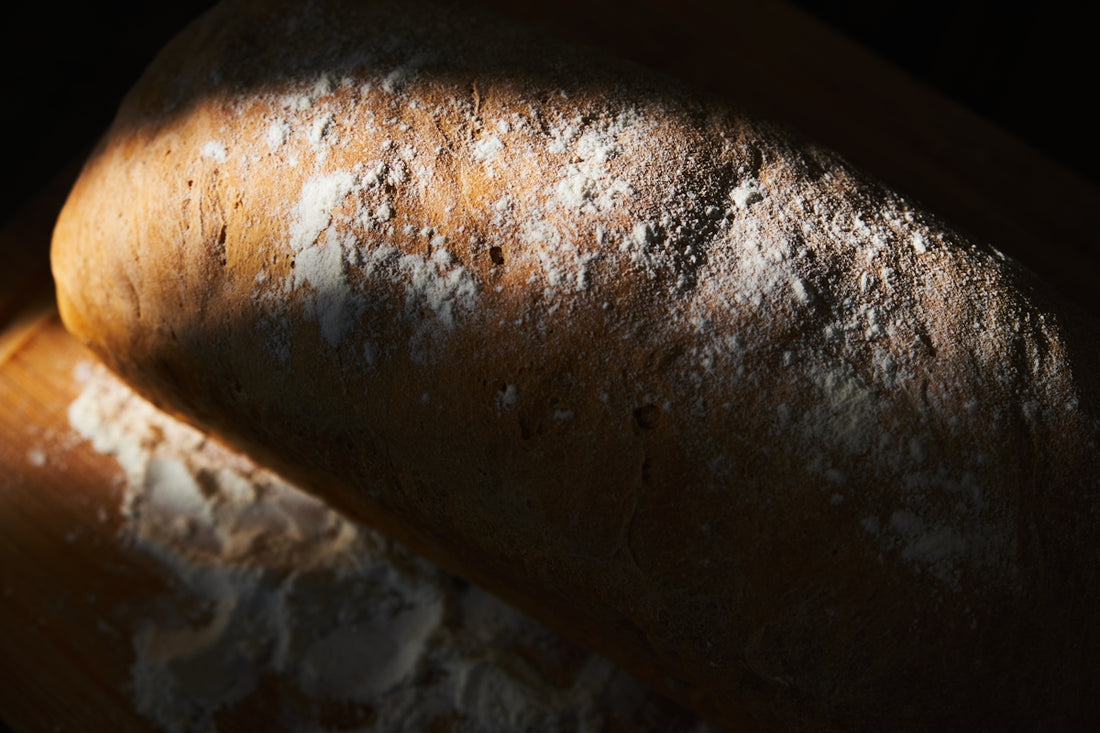 a loaf of bread sitting on top of a wooden cutting board