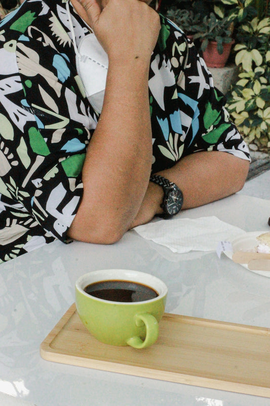a man sitting at a table with a cup of coffee