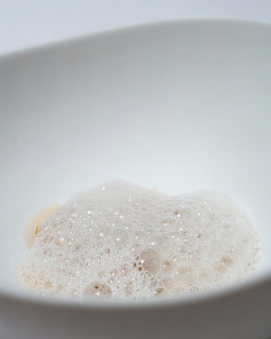 A white bowl filled with water and bubbles