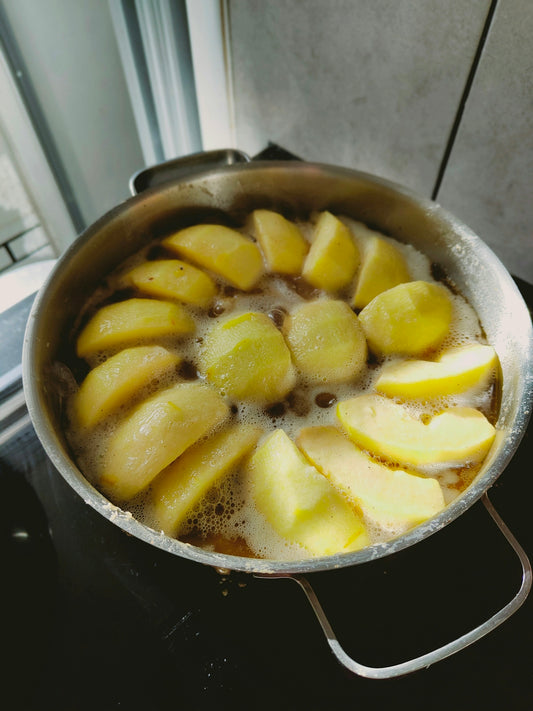 a pan filled with sliced apples on top of a stove